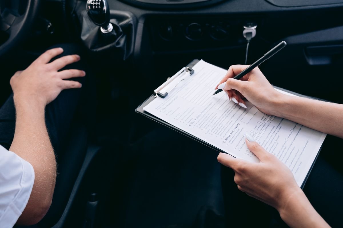 A person reviewing and documenting a vehicle repair estimate on a clipboard