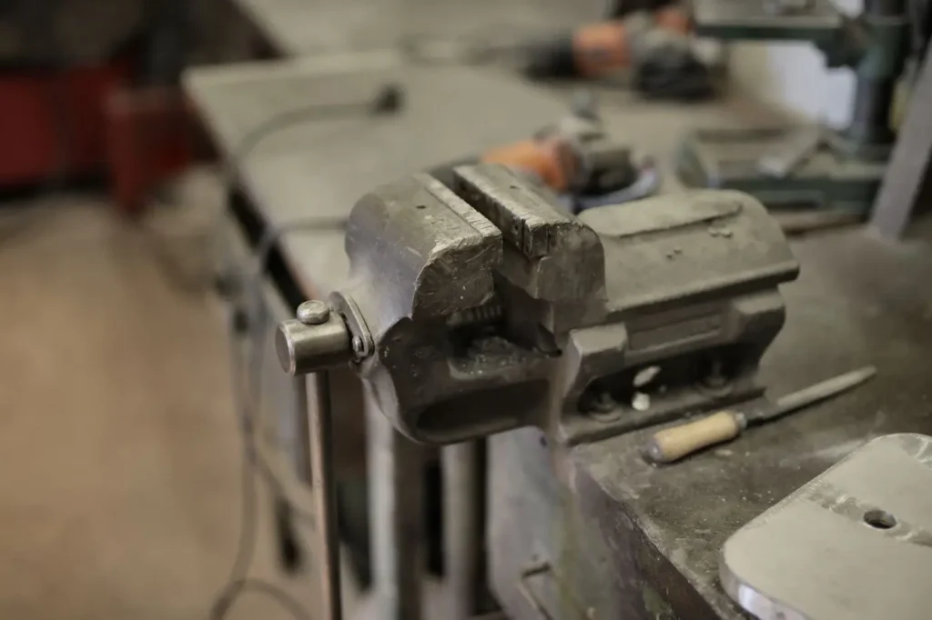 A workbench vice and assorted hand tools in a training workshop