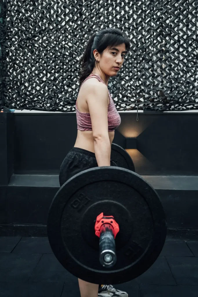 An athlete lifting a barbell indoors during a strength session